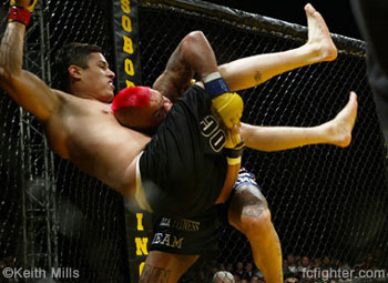 Jake Gomez holding the cage to prevent the Thomas Denny takedown